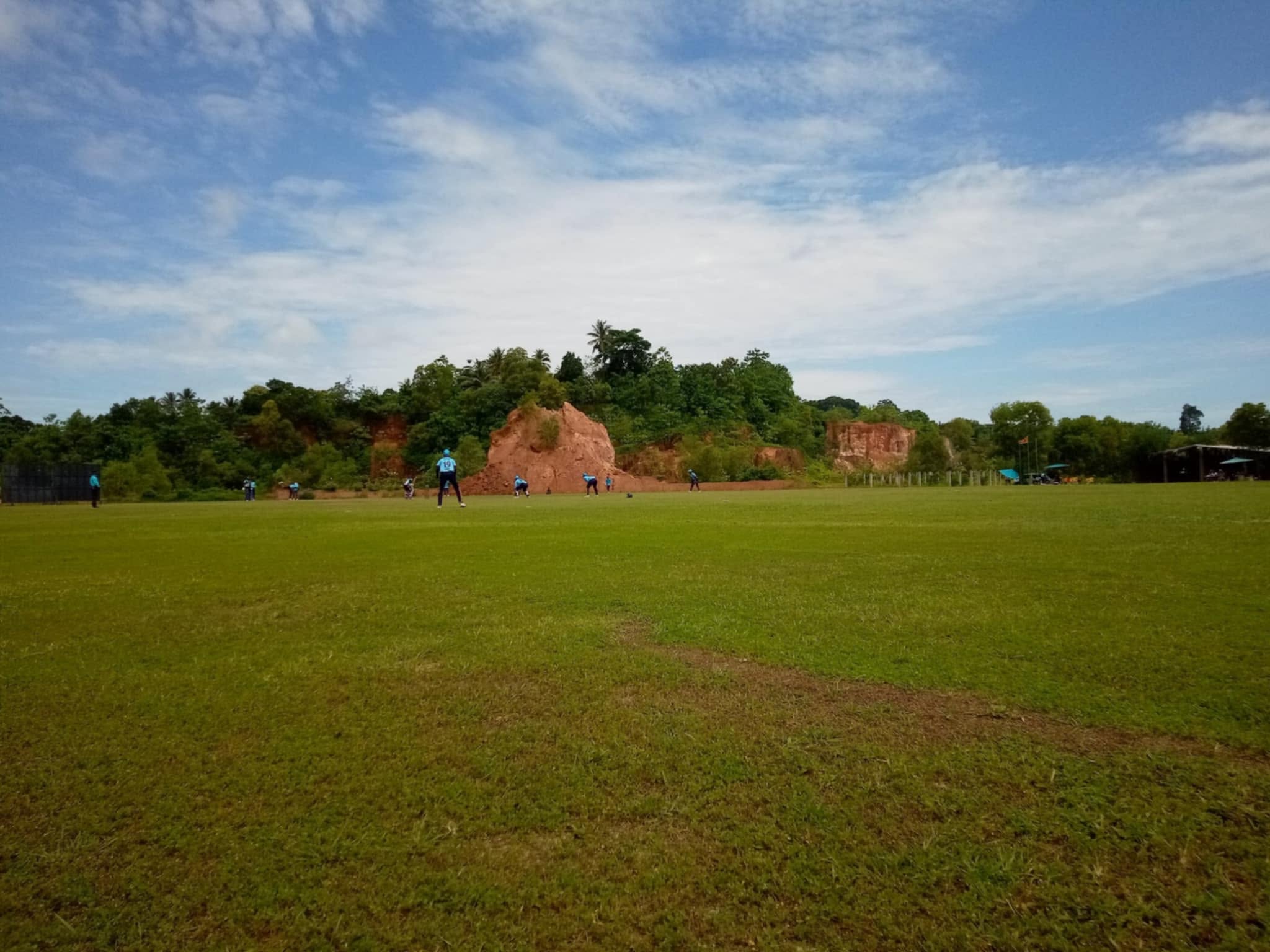 Fielding action against the red-rock backdrop - DHH Turf Cricket Grounds Negombo Sri Lanka